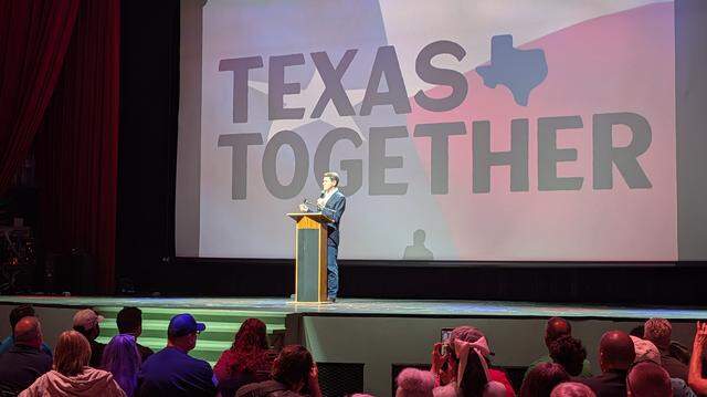 Talarico told the crowd they were on the front lines of a movement to change Texas politics. A man talking on a stage with people below him trying to take pictures.