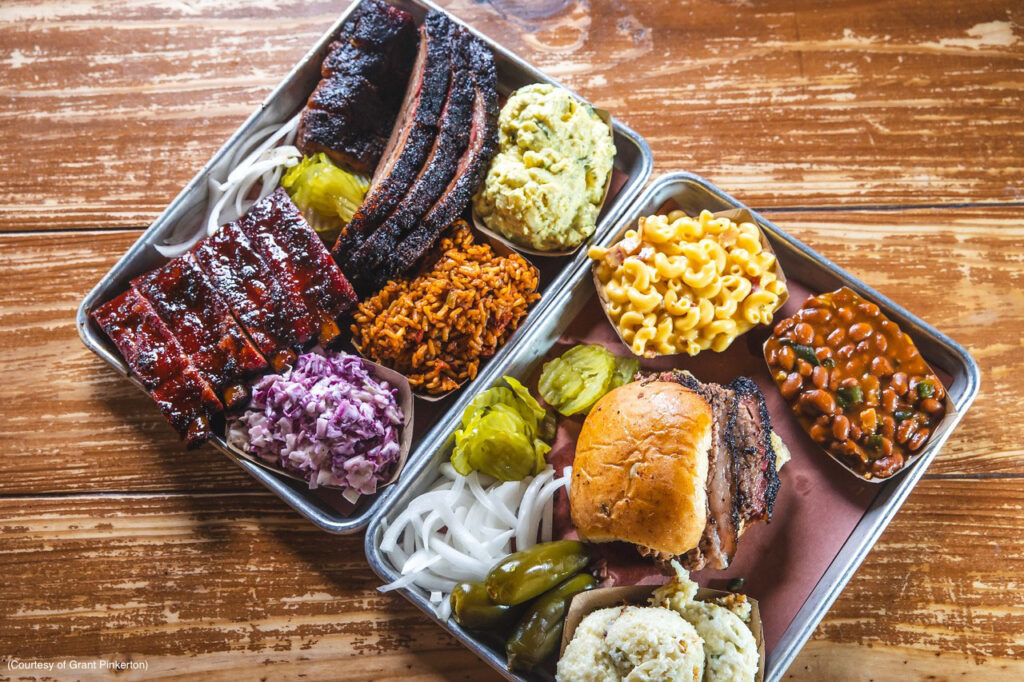 Two trays of barbecue meat and side dishes (Courtesy of Grant Pinkerton)