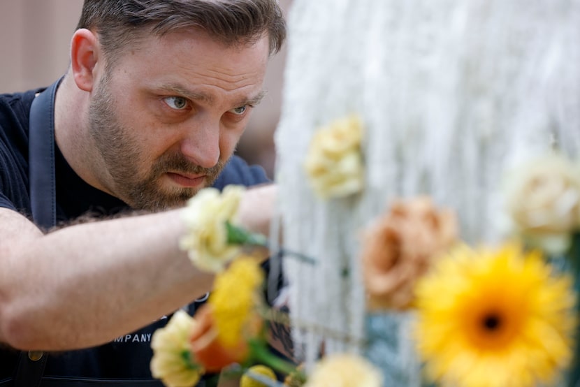 James Claxton, of Hawthorne’s Floral Co., places flowers on a mannequin display in...
