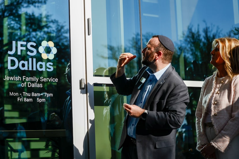 Rabbi Mordechai Harris places a mezuzah at the entrance to the new Jewish Family Service of...