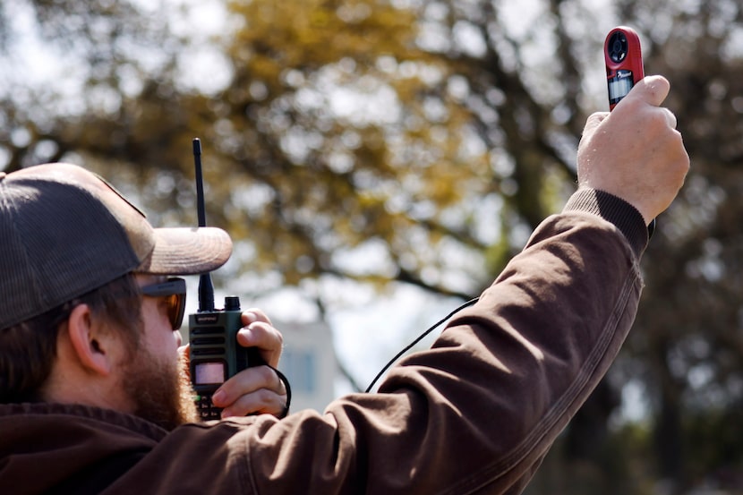 North Texas Prescribed Burn Association member Don Nelson radios wind speed and direction to...
