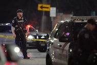 Austin police officers work at the scene on West Sixth Street after a shooting outside...