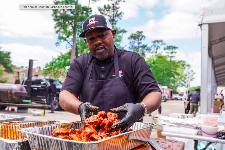 Image shows a chef preparing a tray of barbecue at Houston Barbecue Fest. 
