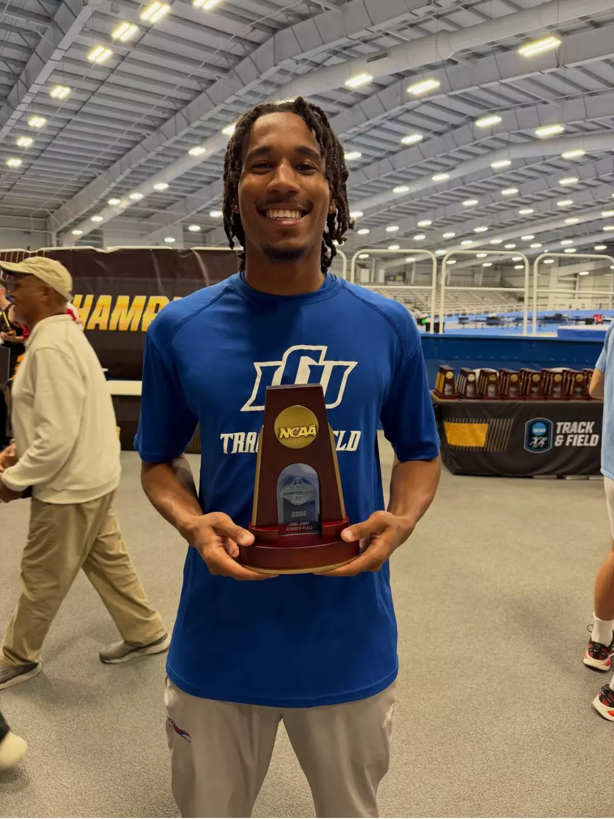 This is a photo of Maurice Gray with his seventh place long jump trophy.
