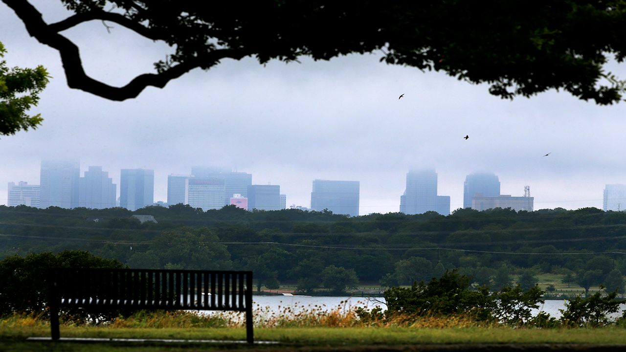 White Rock lake is seen in the foreground as storm clouds linger over the Dallas city skyline, Thursday, July 17, 2014. (AP Photo/Tony Gutierrez)