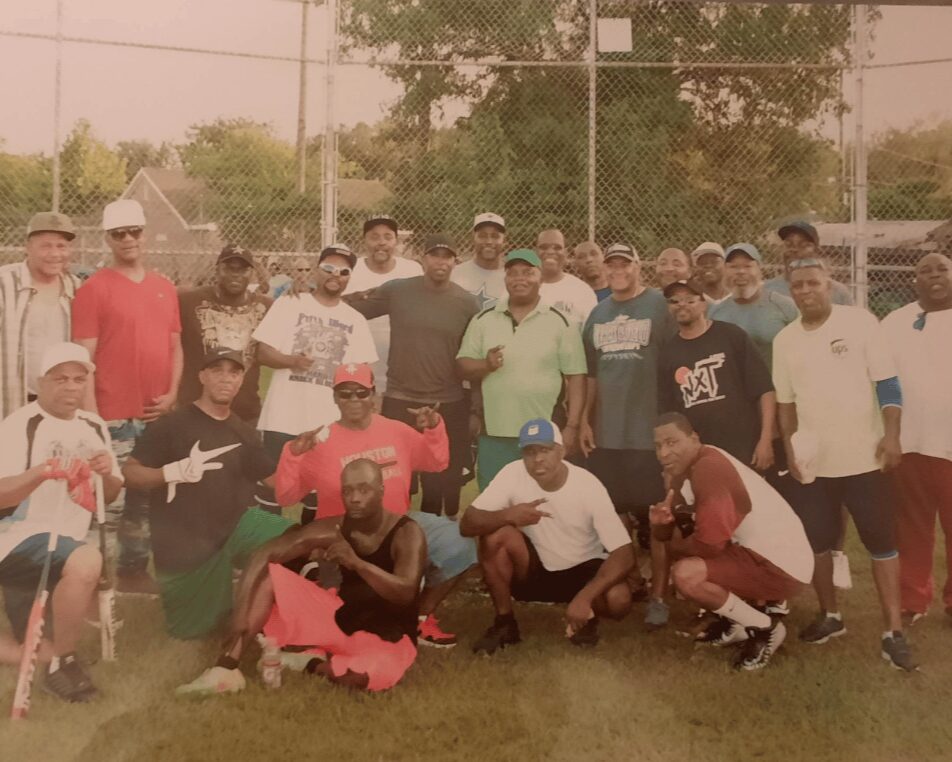 Coach James Robert Hall, center, stands with former members of the Tuffly Park Colts baseball team for a reunion game. 