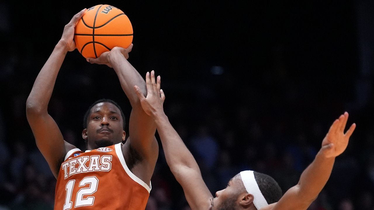 Texas guard Tramon Mark (12), left, scores a go-ahead basket with 1 second remaining during the second half in a First Four college basketball game in the NCAA Tournament against North Carolina State, Tuesday, March 17, 2026, in Dayton, Ohio. (AP Photo/Kareem Elgazzar)
