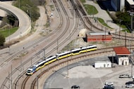 A DART train makes the bend as it passes Reunion Tower on the way to Union Station in...