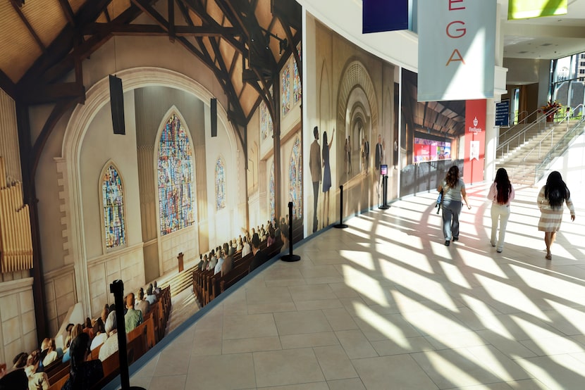 First Baptist Dallas worshipers pass by a large artist rendering of the new historic...