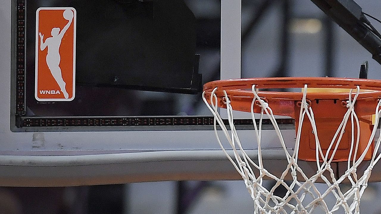 The WNBA logo is seen near a hoop before an WNBA basketball game at Mohegan Sun Arena, Tuesday, May 14, 2019, in Uncasville, Conn. (AP Photo/Jessica Hill)