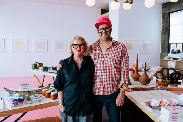 A photograph of Buck Johnson and Camp Bosworth standing in their art gallery and store. 