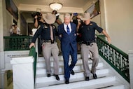Texas megachurch founder Robert Morris is escorted out of the building after pleading guilty...