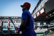 Texas Rangers outfielder Andrew McCutchen picks up a bat before taking batting practice...