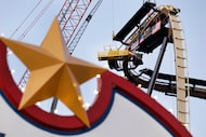 Sparks fly from a man basket as construction crews fit the crowning piece of the new...