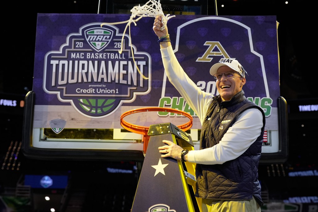 Akron head coach John Groce waves the net after Akron defeated Toledo in an NCAA college basketball game in the championship of the Mid-American Conference tournament, Saturday, March 14, 2026, in Cleveland.