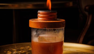 A flame burns atop the lid atop a glass of the opium den cocktail at Apothecary.