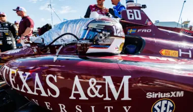 A race car helmet sits on a Texas A&M-branded race car