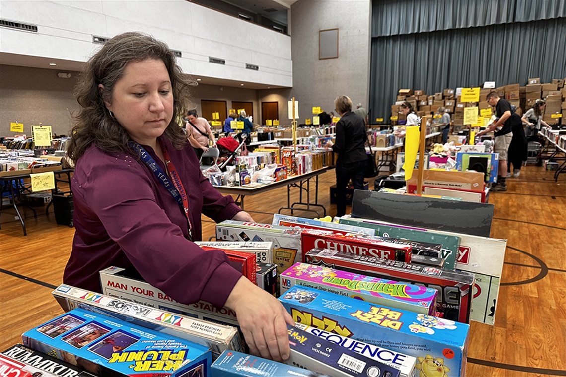 woman looking through items at book sale benefitting the Arlington Public Library