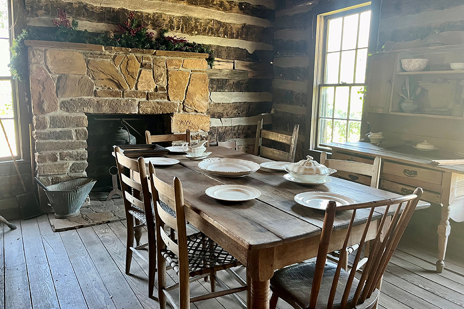 Wooden table with white plates on the table top inside wooden building at Knapp Heritage Park.