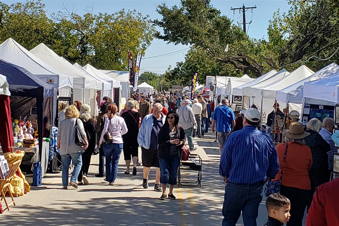 People walking along South Street with tents and vendors set up for South Street Arts Festival.