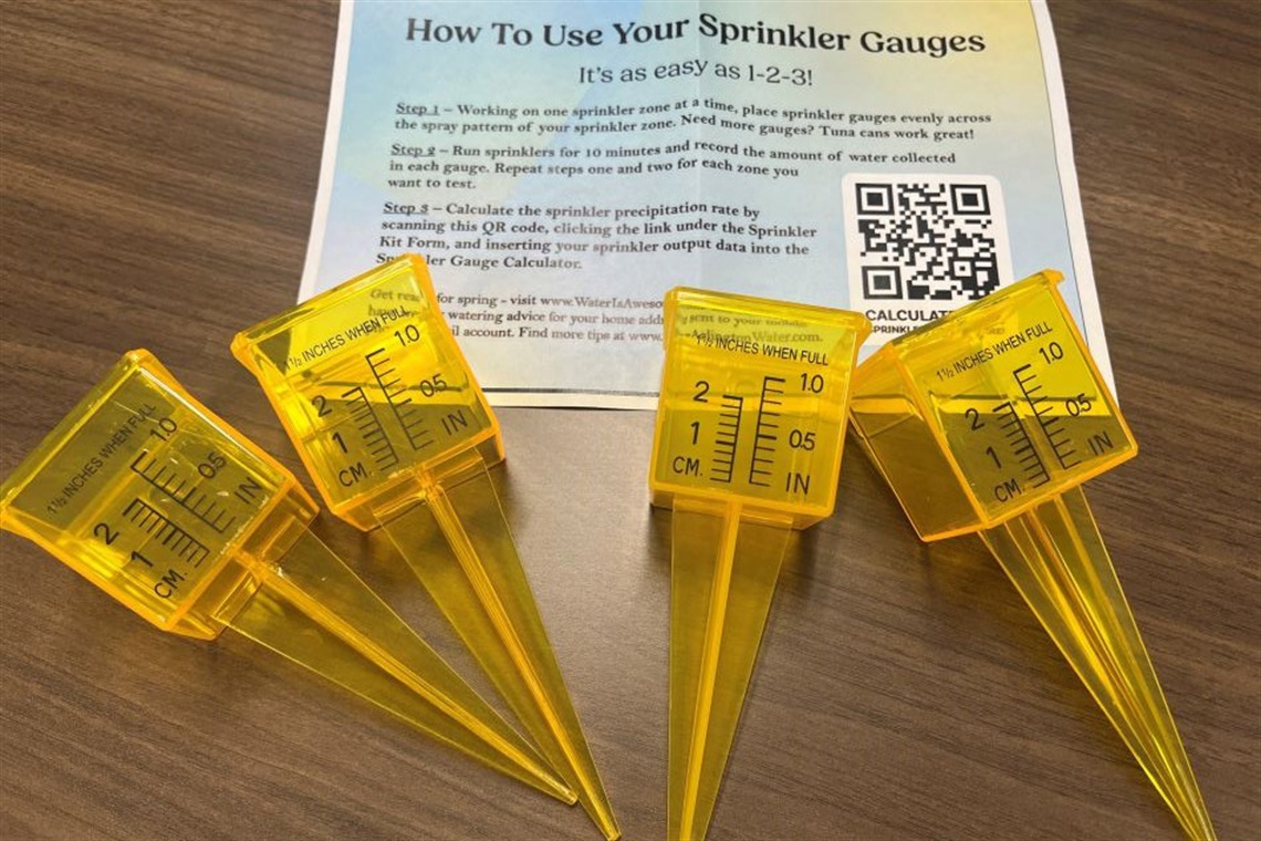 Four yellow sprinkle gauge on a wooden table. 