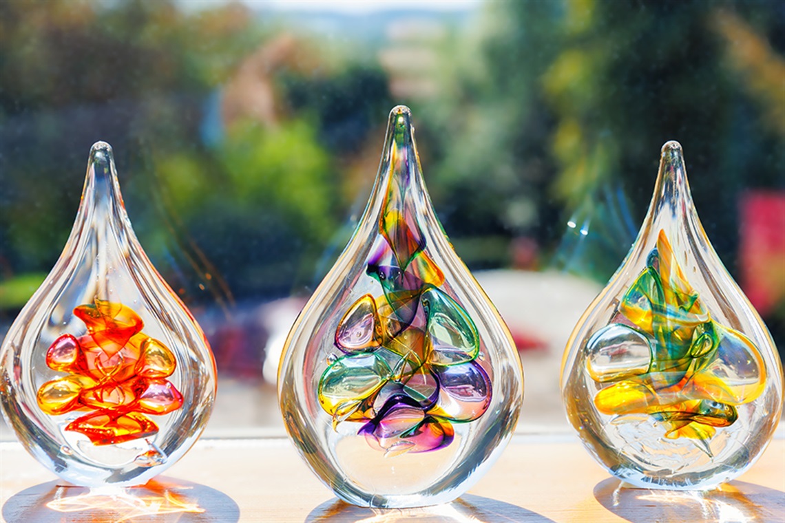 Colorful glass art sculptures displayed in sunlight.