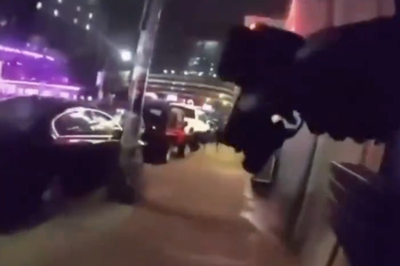 Terrified bystanders can be seen hiding and pointing officers in the direction of the shooter