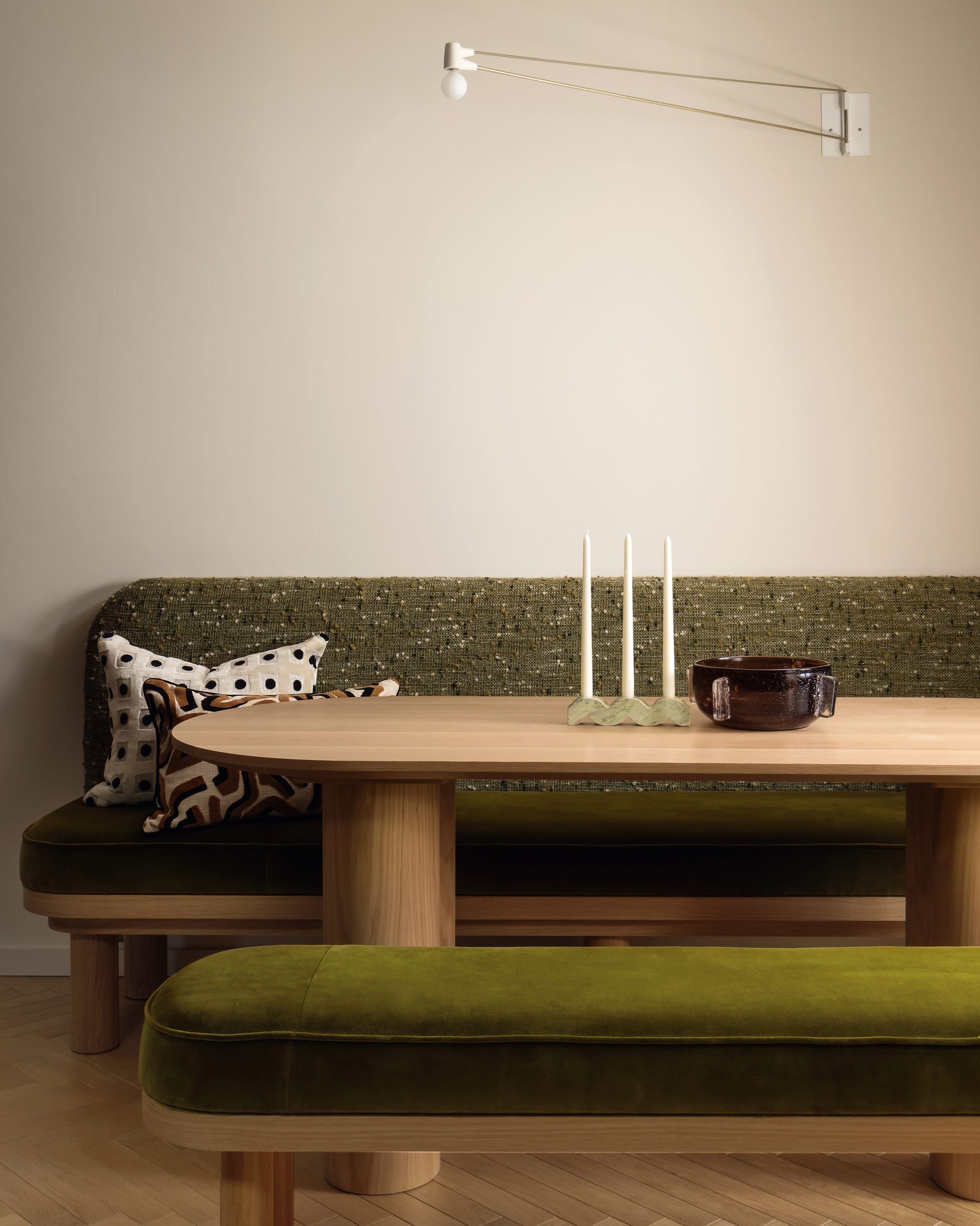 Dining area featuring green upholstered seating and a wooden table.