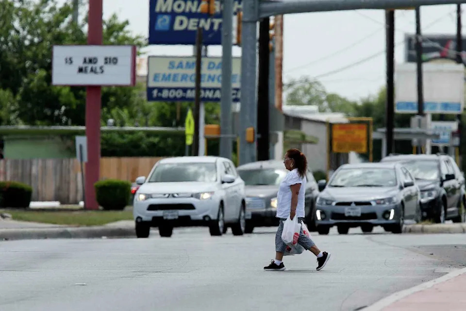 A woman crosses Culebra Road at the NW 24th Street intersection in 2018. Culebra is one of the busiest roads to try to cross as a pedestrian. (Jerry Lara /Staff photographer)