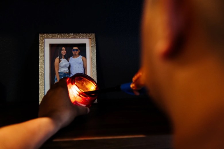 Juan Rodriguez lights a candle beside a photograph of his fiancée, Johanny Lacruz, whose return he prays for each night after she was detained by U.S. Immigration and Customs Enforcement. Lacruz, a Venezuelan woman who entered the U.S. through the CBP One app, is currently being held at a detention facility in Raymondville. 