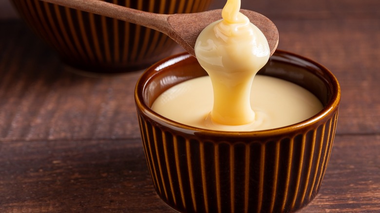 Fresh condensed milk in a brown ramekin