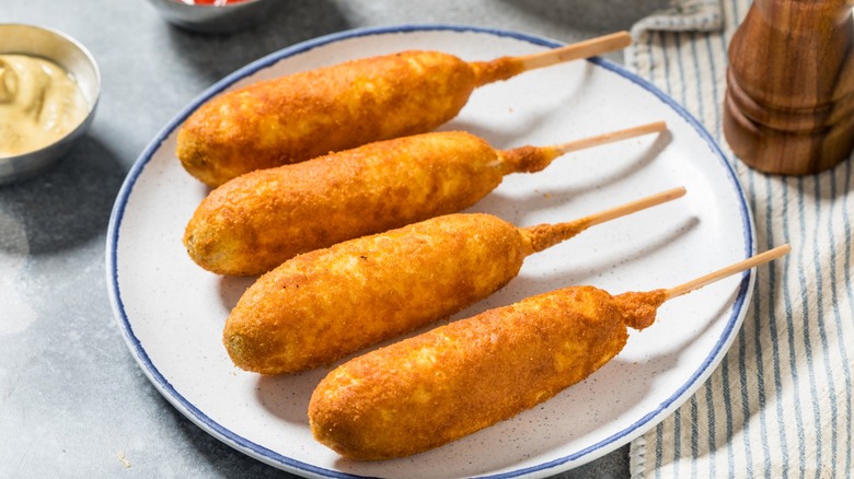 Corn dogs on a white plate with a blue rim