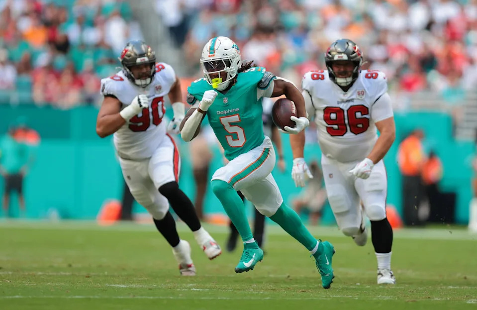 Miami Dolphins running back Jaylen Wright (5) runs for a gain past Tampa Bay Buccaneers defensive end Logan Hall (90) and defensive tackle Greg Gaines (96) during the first quarter. Sam Navarro-Imagn Images