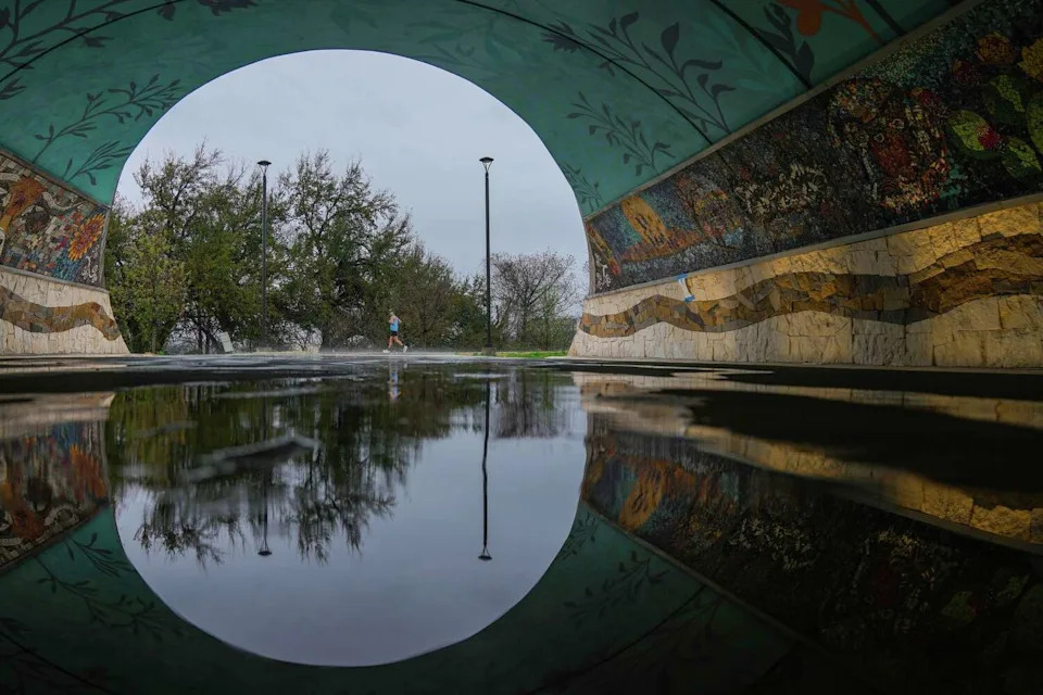 A jogger proceeds down the trail near the Wishbone Bridge as a weekend of rain impacts the Austin area, March 7, 2026. (Sara Diggins/Austin American-Statesman)