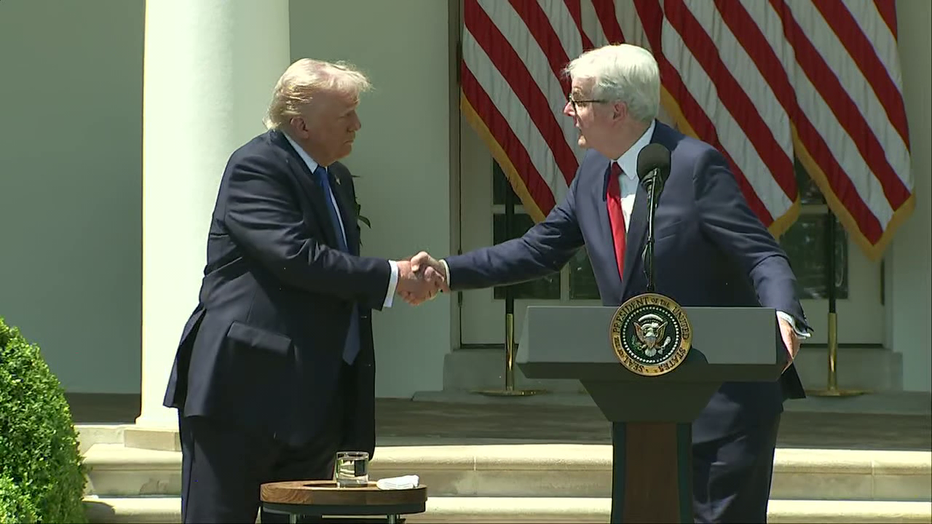 President Donald Trump and Texas Lt. Gov. Dan Patrick hake hands during a speech at the White House on May 1, 2025.