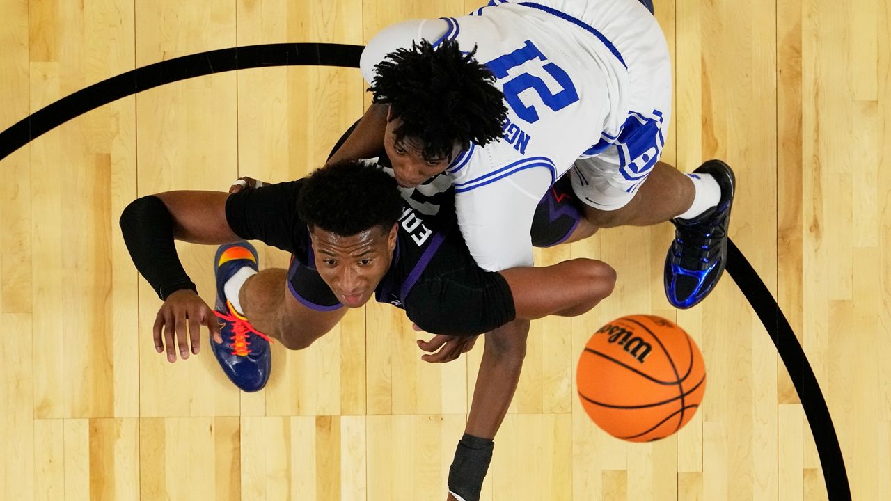TCU forward Xavier Edmonds and Duke center Patrick Ngongba II battle for a rebound during the first half of a second-round NCAA college basketball tournament game Saturday, March 21, 2026, in Greenville, S.C. (AP Photo/Chris Carlson)