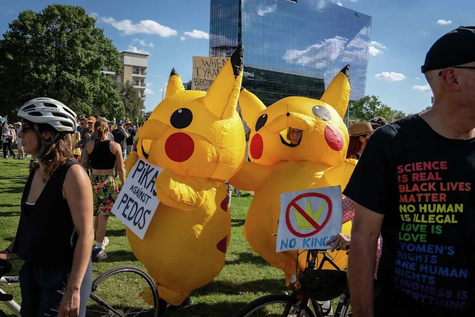 Two protesters wearing inflatable Pikachu costumes walk through Auditorium Shores after marching with thousands of others from the Texas State Capitol for the No Kings rally, Oct. 18, 2025. The rally against President Donald Trump and his policies included speakers, a march from the Texas State Capitol to Auditorium Shores and live music and occurred in conjunction with others across the country. (Sara Diggins/Austin American-Statesman)