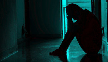 A photographic illustration of a person sitting on the ground from stress.