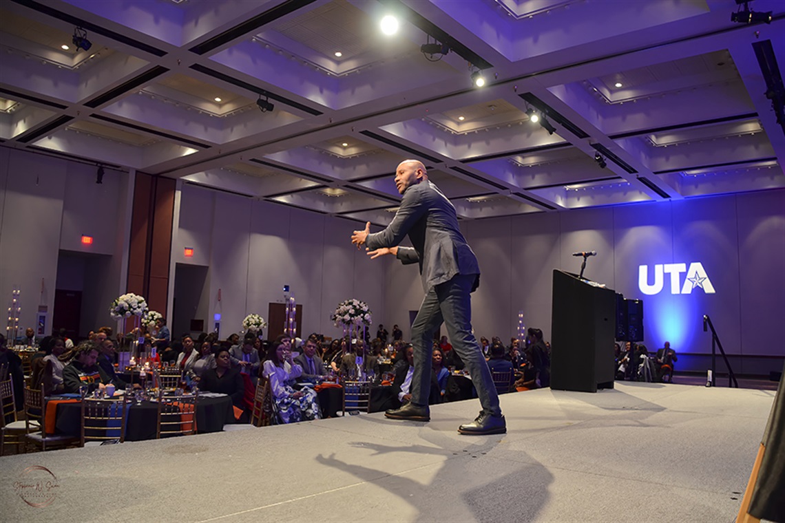 Man on stage speaking to guests of the Arlington MLK Gala.