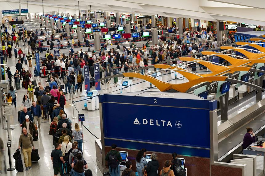 Travelers wait in line at Hartsfield-Jackson Atlanta International Airport on March 25, 2026, in Atlanta.
