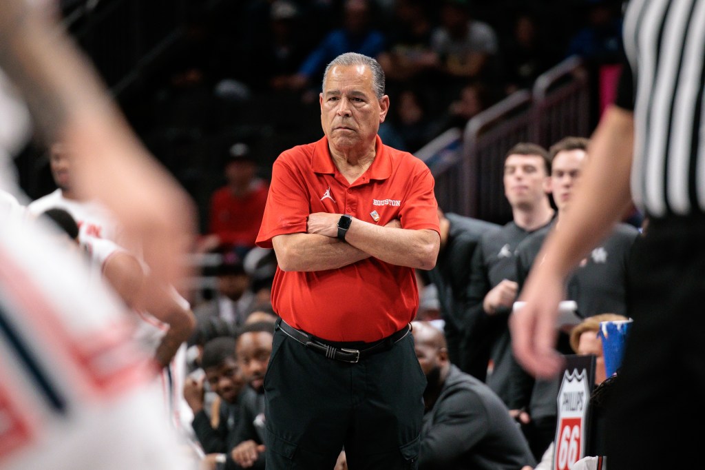 Houston Cougars head coach Kelvin Sampson watches gameplay with his arms crossed.