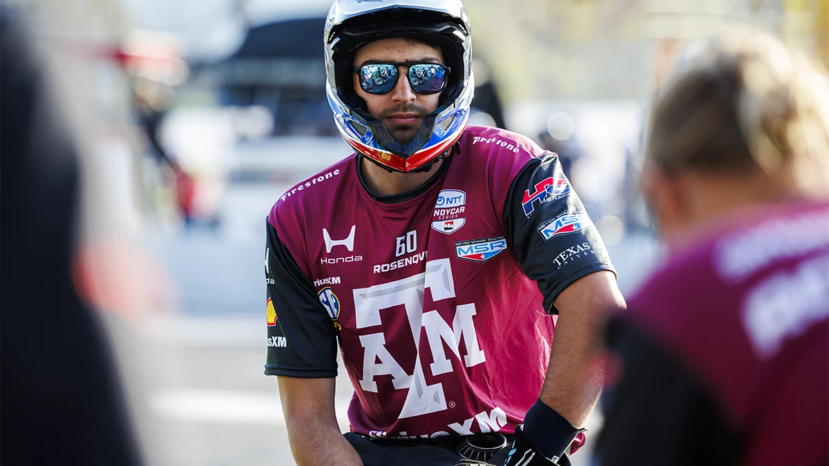 Person in Texas A&M racing jersey and helmet faces the camera