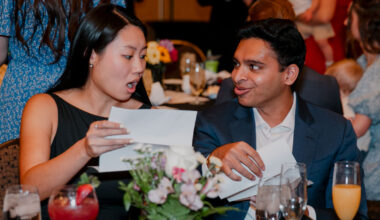 One man and one woman each open their match envelopes with surprised looks on their faces.