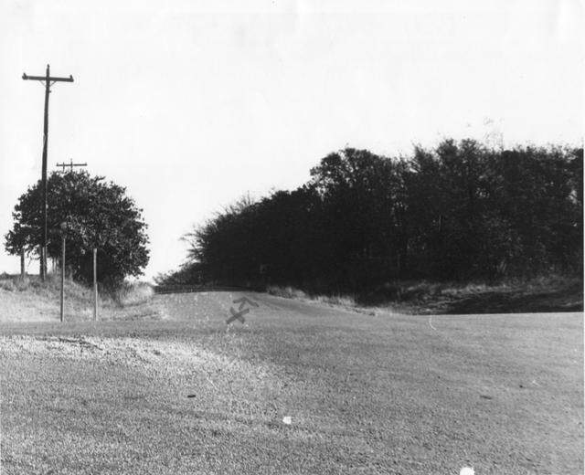 Photograph of a then-dirt road (Dove Road, off Texas 114) in Southlake, Texas. An “x” on the photo indicates the spot where the Bonnie and Clyde gang killed two law officers on April 1, 1934.