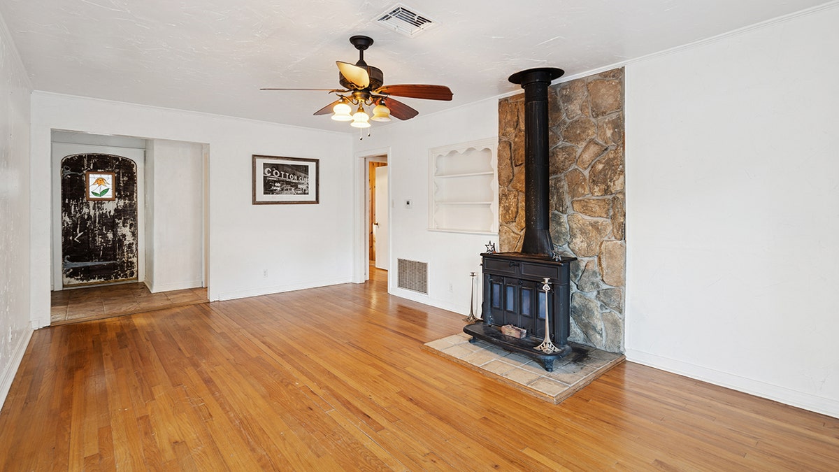 The living room in the pink house also features a fireplace.