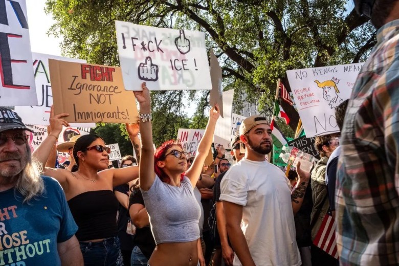 Protesters hold up signs during a "No Kings" protest staged downtown last June.
