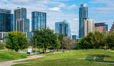 A park on a sunny day with cityscape of Austin Texas in the background.