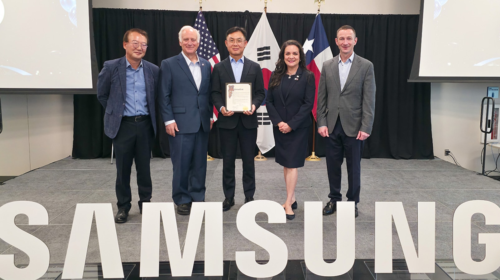 Austin Mayor Kirk Watson presented Samsung Austin Semiconductor with a proclamation for the company's 30th anniversary. From left to right: Jeffrey Go, corporate executive vice president, Samsung Austin Semiconductor; Austin Mayor Kirk Watson; Bonyoung Koo, president, Samsung Austin Semiconductor; Adriana Cruz, executive director, Texas Economic Development and Tourism; Jon Taylor, executive vice president, Samsung Austin Semiconductor. 