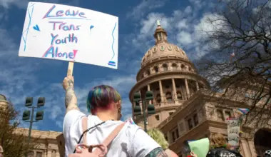 Demonstrators hold signs in support of transgender youth and rights in response to recent proposed legal action against parents seeking gender affirming healthcare for their children to be charged as child abuse at the Rally for Trans Youth at the Texas State Capitol on Mar. 1, 2022.