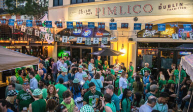 A crowd of green-clothed people outside of a pub
